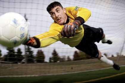 Man Catching Soccer Ball on Field