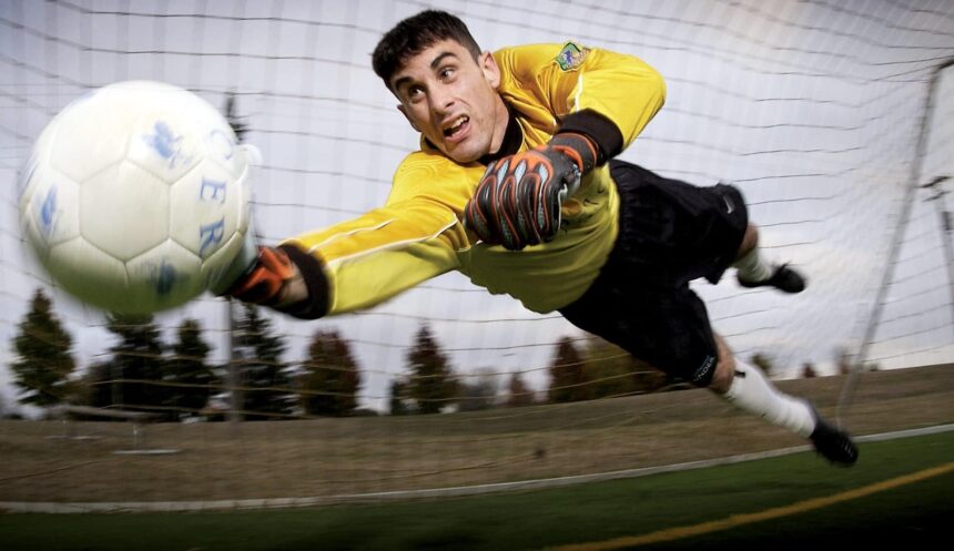 Man Catching Soccer Ball on Field